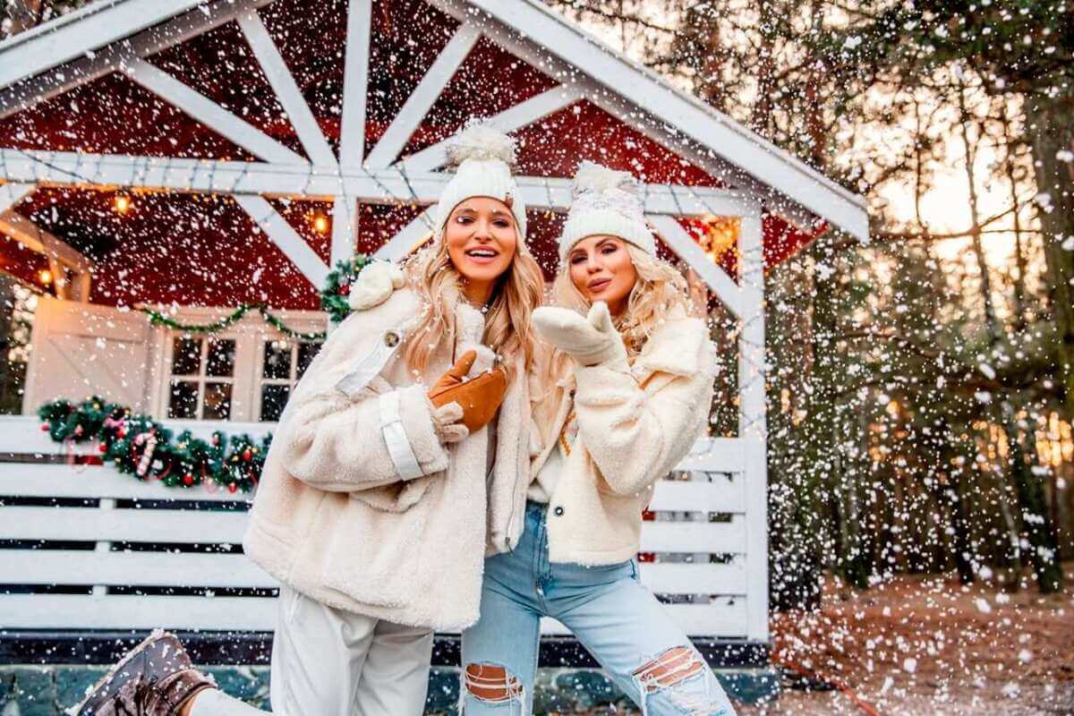 Dwie modelki pozują w padającym śniegu i promują zimowe stylizacje z hurtowni Factoryprice.eu